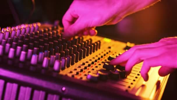 사운드 엔지니어는 라이트 클로즈업의 오디오 믹서에서 유행을 위아래로 이동시킵니다 콘솔의 — 비디오