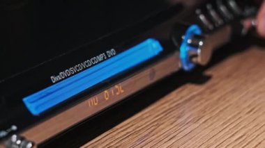 DVD sıkıştırma diski oynatıcıya eklenir. Erkek eli CD 'yi CD çalar tepsisine yakın çekime koyar. Müzik, filmler ya da veriler bir lazer optik bilgi depolama aracına kaydedildi. Küçük Disk Yükleniyor