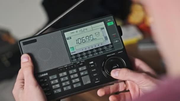 人类拥有一台现代便携式收音机 其数字液晶显示的是广播电台的频率和调频范围内的搜索或扫描 显示大数字调频无线电接收机 — 图库视频影像