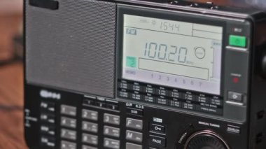 Masada dijital LCD ölçekli FM tarama frekansına sahip modern radyo. Taşınabilir radyo otomatik FM arama menzili. Çevirme paneli değişik radyo frekanslarıyla büyük rakamları gösteriyor. Yakın plan.
