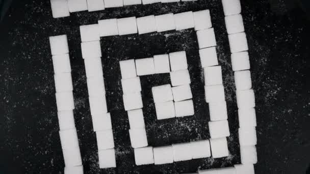 甜甜迷宫顶部视图 许多糖立方体折叠成迷宫状 在黑色背景上旋转 概念糖瘾 不健康的饮食 糖尿病 问题的解决 — 图库视频影像