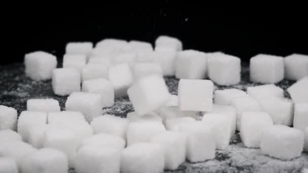 糖立方体以慢动作落在旋转桌子上 靠得很近 硬的白糖落在黑桌上 不健康的饮食 糖尿病 复制空间 — 图库视频影像
