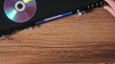 DVD sıkıştırma diski oynatıcıya eklenir. Erkek eli CD 'yi CD çalar tepsisine yakın çekime koyar. Müzik, filmler ya da veriler bir lazer optik bilgi depolama aracına kaydedildi. Küçük Disk Yükleniyor