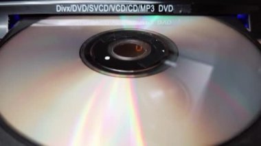 DVD CD oynatıcıdan CD CD indiriliyor. Erkek CD çalar tepsisinden CD 'yi yakın plan çeker. Müzik, filmler ya da veriler bir lazer optik bilgi depolama aracına kaydedildi. Kompakt Disk Çıkılıyor