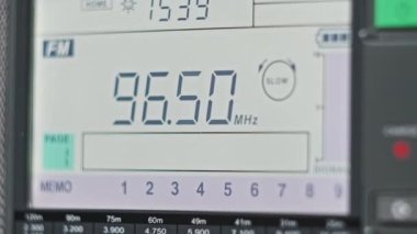Modern Taşınabilir Radyonun Dijital LCD Ölçeklendirmesinde FM Frekansını Kapat. Çevirme paneli değişik radyo frekanslarıyla büyük rakamları gösteriyor. Taşınabilir radyo otomatik arama menzili. Akort alıcısı