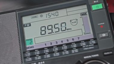 Modern radyonun dijital LCD ölçeğinde FM frekansı taranıyor. Çevirme paneli değişik radyo frekanslarıyla büyük rakamları gösteriyor. Taşınabilir radyo otomatik arama menzili. Akort alıcısı.