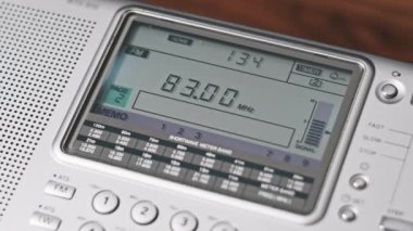 Modern Taşınabilir Radyonun Dijital LCD Ölçeklendirmesinde FM Frekansını Kapat. Çevirme paneli değişik radyo frekanslarıyla büyük rakamları gösteriyor. Taşınabilir radyo otomatik arama menzili. Akort alıcısı