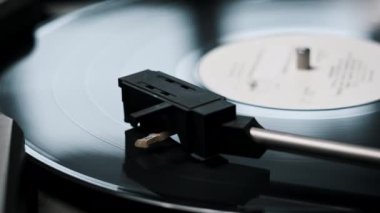 Vinil plak vintage turntable 'da dönüyor, iğne plağa değiyor. El, vinil plağı açar. Stylus yakın plan kayıtlardan yükseliyor. Vinil plak çeviriyorum. Retro müzik çalıyorum. 4K