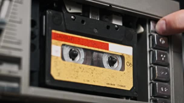 オーディオテープレコーダーの再生 ヴィンテージオーディオカセットをクローズアップして挿入します レトロ レコーダー 古いテープを再生するレコードプレーヤー レトロテープリールはデッキで回転します アーカイブ 80年代を再生する — ストック動画
