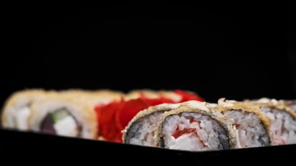 Sushi Rotola Una Scatola Plastica Ruotare Primo Piano Sfondo Nero — Video Stock