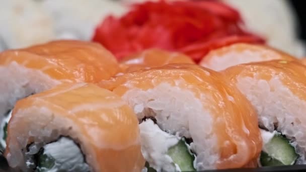 Rolos Sushi Uma Caixa Plástico Giram Close Sobre Fundo Preto — Vídeo de Stock