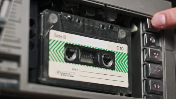 テープレコーダーにオーディオカセットを挿入して再生し 排出し クローズアップします 古いオーディオカセットを再生する レトロプレーヤーのヴィンテージレコードサウンド 再生または再生の会話 デッキで回転するレトロテープリール — ストック動画
