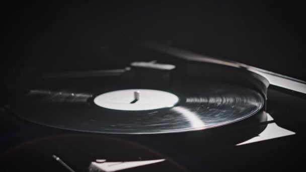 レトロターンテーブルのヴィンテージビニールレコードスピニングクローズアップ ヴィンテージプレーヤーマクロで回転する古いビニールのレコーディング レトロビニル表面を反射するランプの光線 音楽の歴史 ノスタルジック — ストック動画