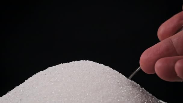 검은색 배경에 덩어리에서 설탕으로 차있는 숟가락을 클로즈업 화이트 설탕의 숟가락을 — 비디오