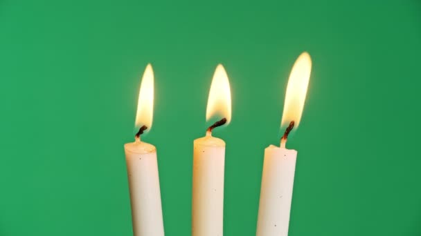 三支蜡烛在绿色色键的背景上燃烧 烛焰特写 复制空间 炽热的烛焰 阿尔法通道背景 孤立无援概念假期 记忆等4K — 图库视频影像