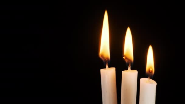 三支蜡烛燃烧并熄灭在黑色的背景上 复制空间 烛焰特写 炽热的烛焰 孤立无援概念纪念 记忆等 — 图库视频影像