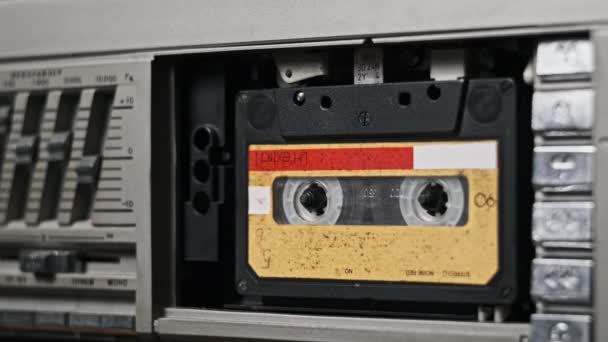 オーディオテープレコーダーの再生 ヴィンテージイエローオーディオカセットをクローズアップして挿入します 古いテープを再生するレコードプレーヤー レトロテープリールはデッキで回転します アーカイブ 80S 4Kのレコーディング — ストック動画