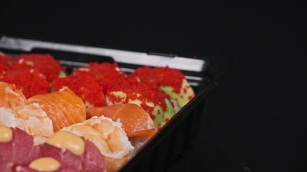 회전하는 상자에 분류하고 검은색 배경으로 설정합니다 컨테이너 클로즈업에서 수있는 일본식 — 비디오