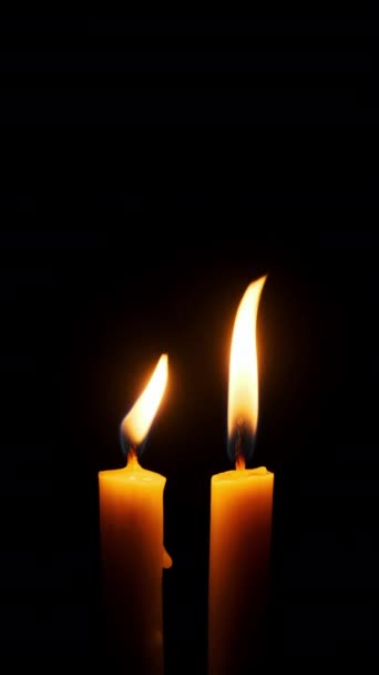 垂直的两支蜡烛在黑色的背景上燃烧和熄灭 复制空间 蜡烛的火焰点燃了特写 熊熊烈火 灯火辉煌 孤立无援概念纪念 记忆4K — 图库视频影像