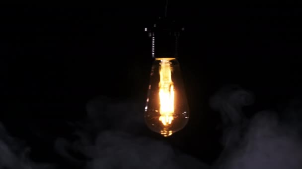 Transparente Klassische Glühbirne Die Draht Hängt Und Auf Schwarzem Hintergrund — Stockvideo