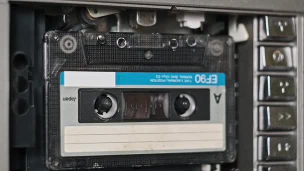 テープレコーダーにオーディオカセットを挿入し エジェクト クローズアップ 古いオーディオを再生する レトロプレーヤーのヴィンテージレコードサウンド テープリールはデッキで回転します アーカイブ 80年代を再生する — ストック動画