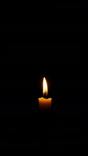 一根垂直的蜡烛燃着 在黑色的背景上熄灭 复制空间 蜡烛的火焰点燃了特写 熊熊烈火 灯火辉煌 孤立无援概念纪念 记忆4K — 图库视频影像