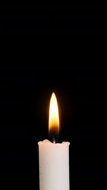 一根垂直的蜡烛燃着 在黑色的背景上熄灭 复制空间 蜡烛的火焰点燃了特写 熊熊烈火 灯火辉煌 孤立无援概念纪念 记忆4K — 图库视频影像