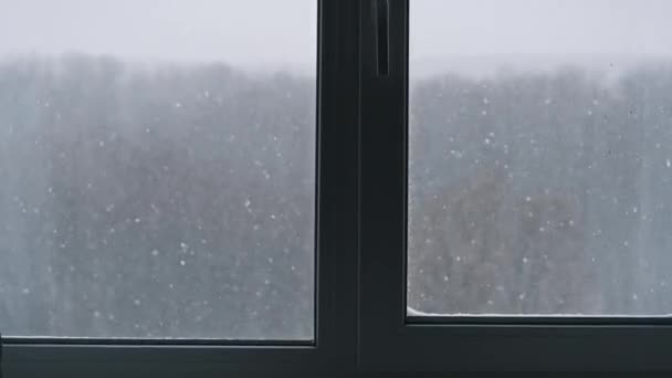 窗外的冬景 冬天的风景通过窗户在房子里 美丽的冬季背景 冬天在外面下着雪 外面下着几片雪 户外运动 — 图库视频影像