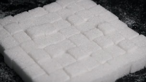 糖立方体旋转的特写 许多精炼的白色方块被折叠成正方形 在黑色的背景上平滑旋转 不健康的饮食 糖尿病 复制空间 — 图库视频影像
