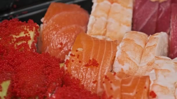 Różne Sushi Bułki Obracającym Się Polu Dostawy Ustawione Czarnym Tle — Wideo stockowe