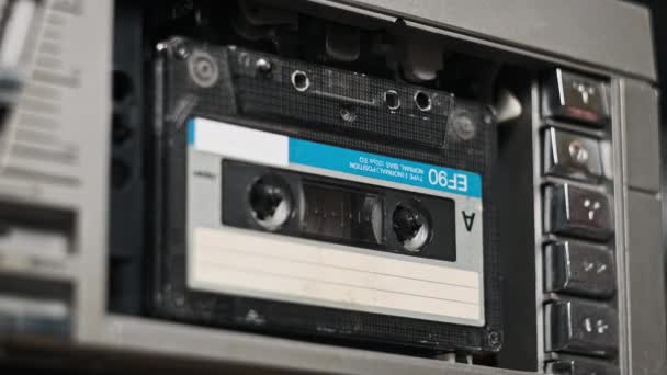 在录音机中插入盒式磁带 并播放 播放旧盒式磁带 复古留声机中的复古录音 听或回放对话 卷筒纸在甲板上旋转 — 图库视频影像