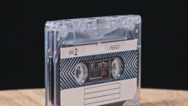 Audiocassette Draait Een Houten Tafel Zwarte Achtergrond Close Vintage Audiotape — Stockvideo