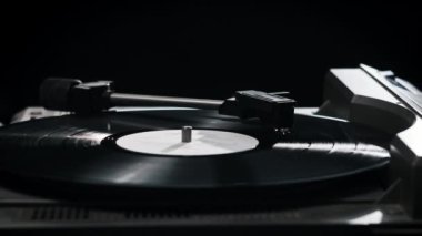 Vinil plak, retro turntable 'da dönüyor. İğne, vinil kapağa değiyor. El, vinil plak açar. Stylus plaklara düşüyor. Vinil plak çeviriyorum. Retro müzik çalınıyor