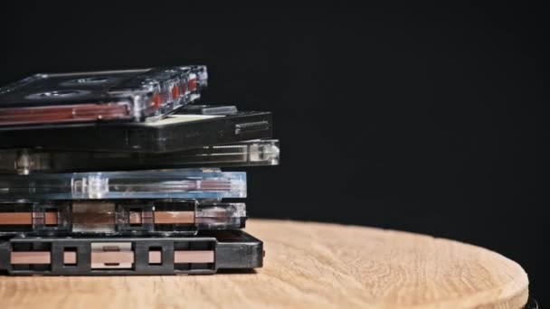 许多不同的盒式磁带堆在一起 在黑色背景的特写下旋转 不同的老式录音带旋转 旧的录音带躺在宏观里 古典音乐复古音乐80年代90年代怀旧 — 图库视频影像