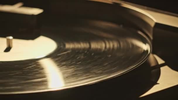 复古乙烯唱片在复古转盘上旋转的特写 老式的乙烯唱片在老式播放器宏中旋转 在复古乙烯表面反射的灯光 音乐史 — 图库视频影像