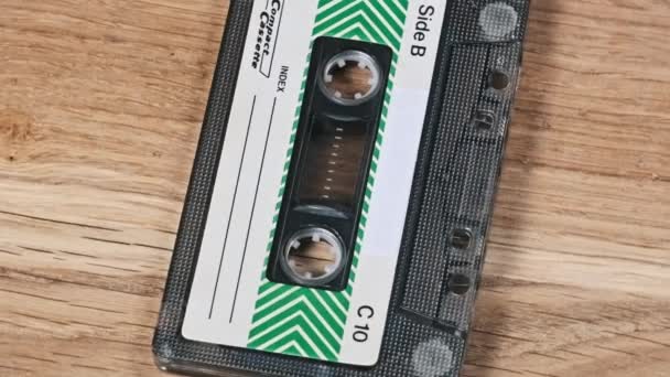 Vintage Ljudkassett Ligger Och Roterar Ett Träbord Närbild Vintage Ljudband — Stockvideo