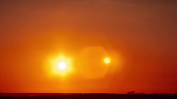 明確なオレンジ色の空に移動するレンズフレアとタイムラプス素晴らしい夕日 明るい太陽が地平線の上に沈んでいる エピック 鮮やかな色 タイムラップス 美しい日没 4Kについて — ストック動画