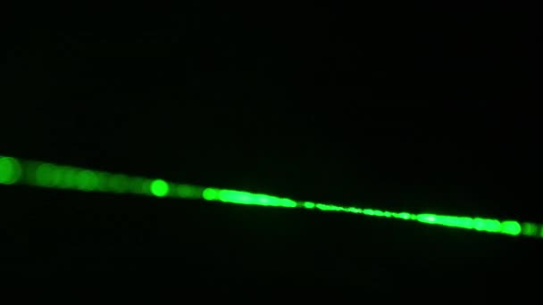 緑色のレーザー光線が黒い背景に閉じ込められています 霧の中で輝く1つのパワーレーザービーム 暗闇の中を切断する明るいパワーレーザー 研究の概念 — ストック動画