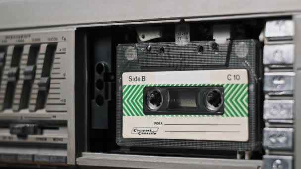 テープレコーダーにオーディオカセットを挿入し エジェクト クローズアップ 古いオーディオを再生する レトロプレーヤーのヴィンテージレコードサウンド テープリールはデッキで回転します アーカイブ 80年代を再生する — ストック動画