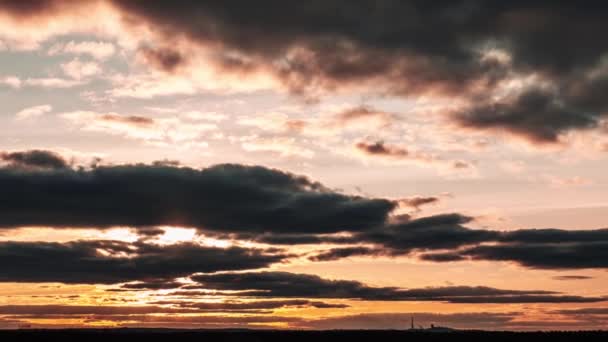 オレンジ色の空の地平線の上のタイムラプスは 劇的な雲で日没しています 4Kについて 明るい太陽が地平線の上に沈んでいる カラフルなダークサンセットの壮大な雲 タイムラプス サンダウン — ストック動画