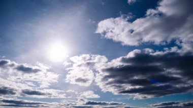 Kümülüs bulutlarının zamanı mavi gökyüzünde ilerliyor. Işık ve ağır sakin bulutların arka planı bulutlu uzayda şekil değiştirir. Doğal arka plan, hızlandırılmış zaman, kopyalama alanı. 4K.