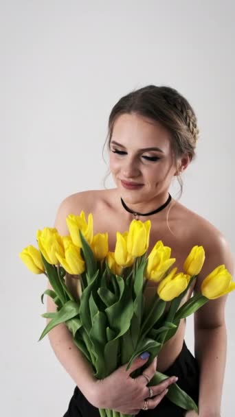 Una Hermosa Joven Maquillada Sostiene Ramo Tulipanes Amarillos Cerca Ella — Vídeo de stock