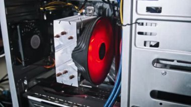 Modern bilgisayar donanımının hassas ve dinamik işlevini vurgulayan kırmızı LED CPU soğutucu fan yakın plan.