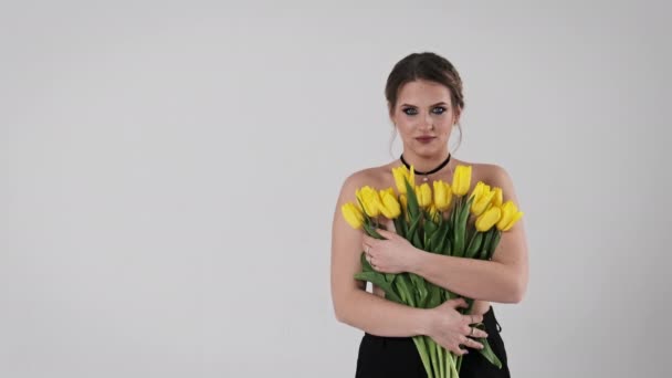 Una Mujer Sostiene Cerca Vívido Ramo Tulipanes Amarillos Sobre Fondo — Vídeos de Stock