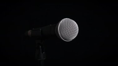 Ses mikrofonu siyah bir arka planda yavaşça döner. Dinamik yüzeydeki krom ızgara yavaşça dönüyor. Konsept kayıt stüdyosu, ses, podcast, karaoke, sesli kitap. Boşluğu kopyala
