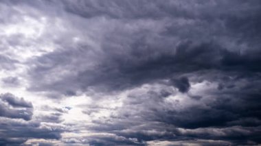 Fırtına bulutları gökyüzünde hareket eder, zaman kavramı. Gri kümülüsün arka planı bulutlu uzayda kalın yağmur bulutları. Dramatik gökyüzünün zaman atlaması. Hava değişikliği. Doğal arka plan, kopyalama alanı. 4K