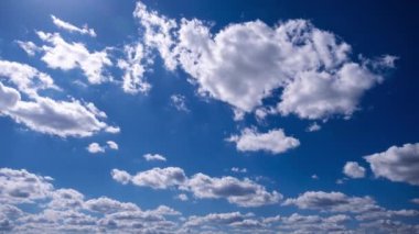 Kümülüs bulutlarının zamanı mavi gökyüzünde ilerliyor. Işık ve ağır sakin bulutların arka planı bulutlu uzayda şekil değiştirir. Doğal arka plan, hızlandırılmış zaman, kopyalama alanı. 4K.