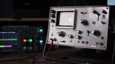 Dinamik yeşil dalga formunu gösteren eski bir osiloskop ekranının büyüleyici görüntüsü. Bu görüntü elektronik, bilim veya geçmişe dönük görsellerle ilgili projeler için mükemmeldir..