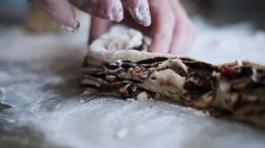 Çikolata, fındık ve yaban mersiniyle dolu hamur köftesini incelikle şekillendiren eller, bu nefis katmanlı pastayı yapmak için gereken sanat ve beceriyi yakalıyor..