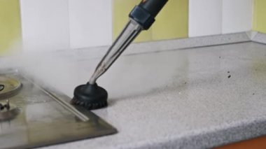 Elle çalışan bir buhar temizleyicisi kirli bir mutfak tezgahına sıcak buhar püskürtür, yüzeyi temizler ve yağ ve kiri temizler. Buhar çamuru eritiyor, lekesiz bir son bırakıyor.